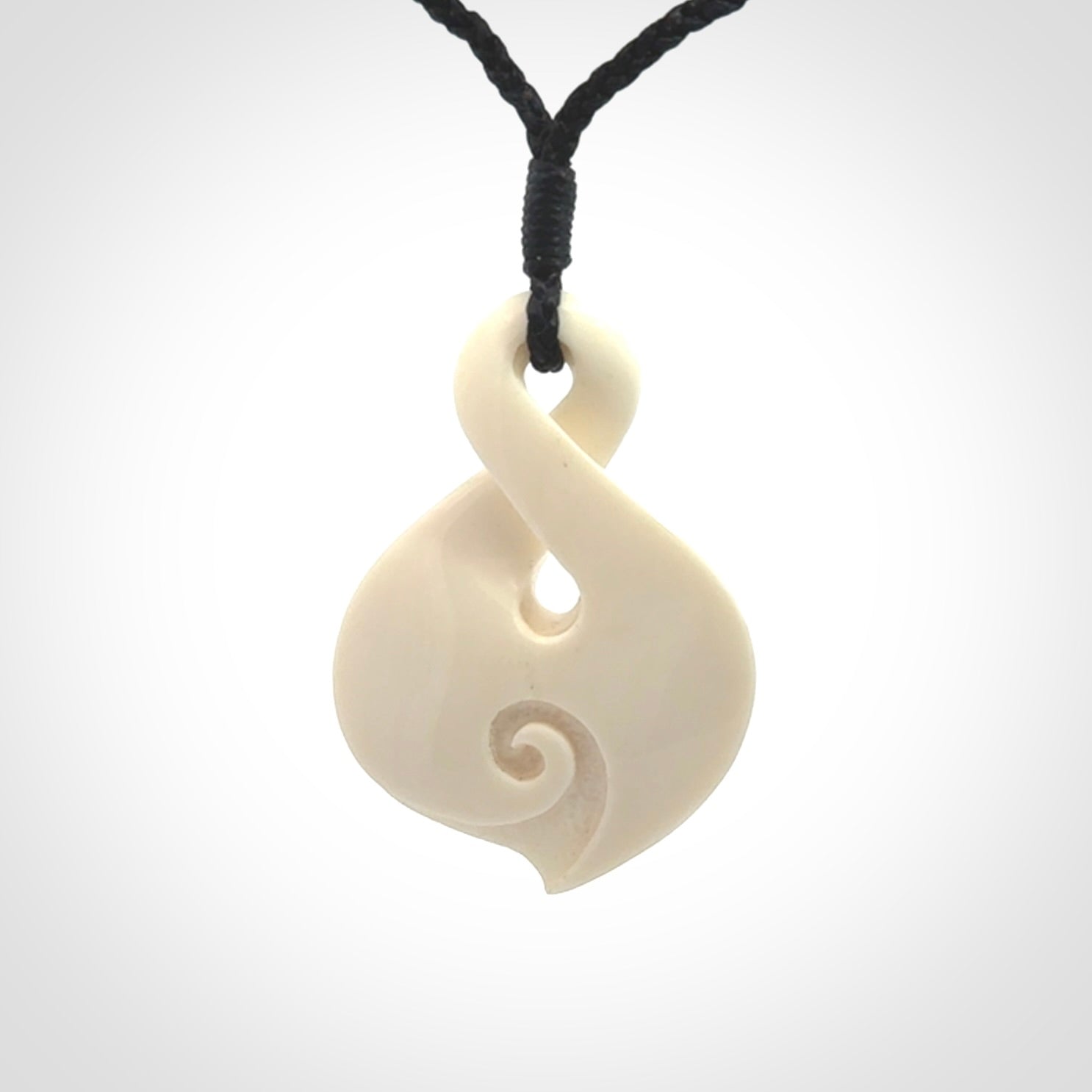 Hand carved bone twist pendant hand made by Peter Mitchell in New Zealand. This bone twist is provided with an adjustable black cord and packaged in a woven kete pouch.