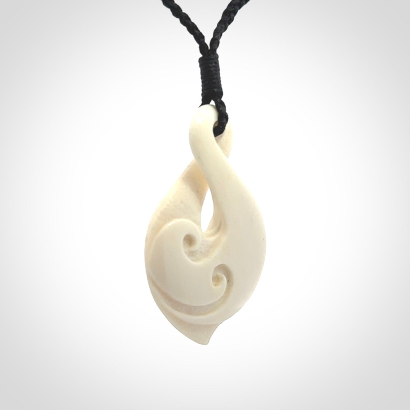 Hand carved bone twist pendant hand made by Peter Mitchell in New Zealand. This bone twist is provided with an adjustable black cord and packaged in a woven kete pouch.