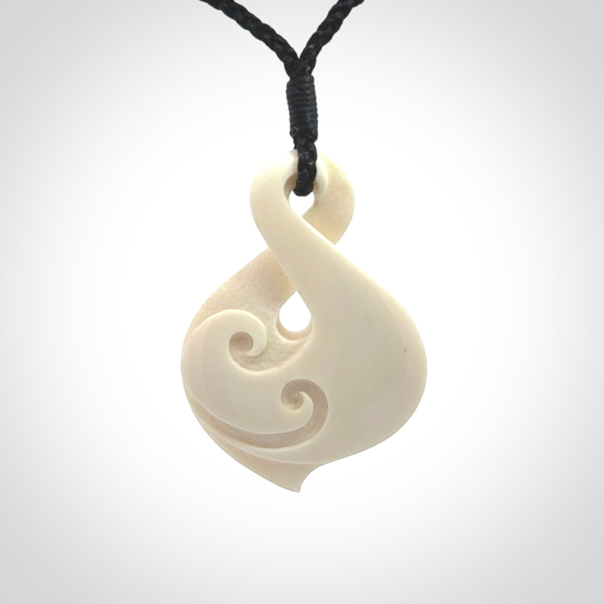 Hand carved bone twist pendant hand made by Peter Mitchell in New Zealand. This bone twist is provided with an adjustable black cord and packaged in a woven kete pouch.