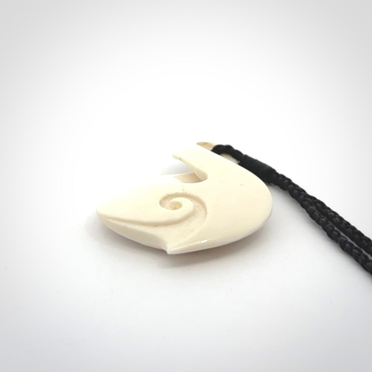 Hand carved bone twist pendant hand made by Peter Mitchell in New Zealand. This bone twist is provided with an adjustable black cord and packaged in a woven kete pouch.