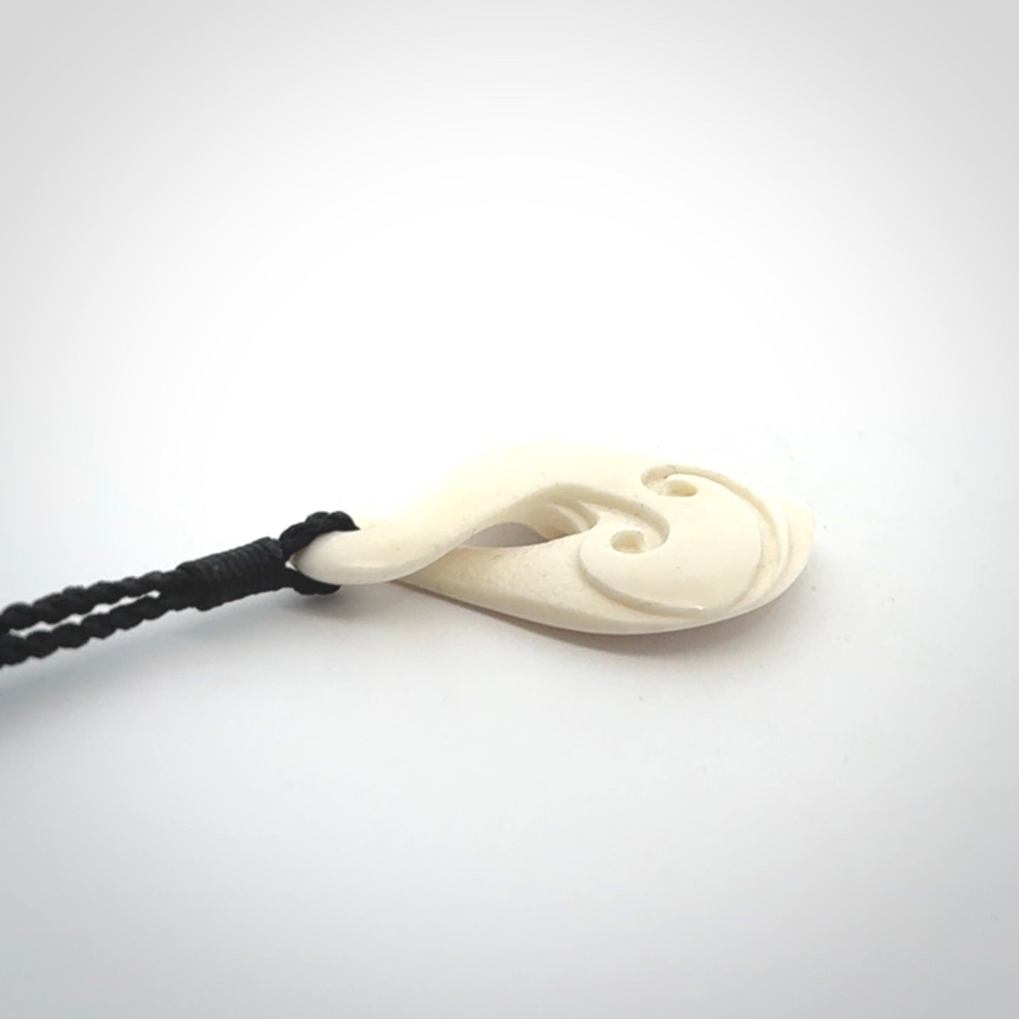 Hand carved bone twist pendant hand made by Peter Mitchell in New Zealand. This bone twist is provided with an adjustable black cord and packaged in a woven kete pouch.