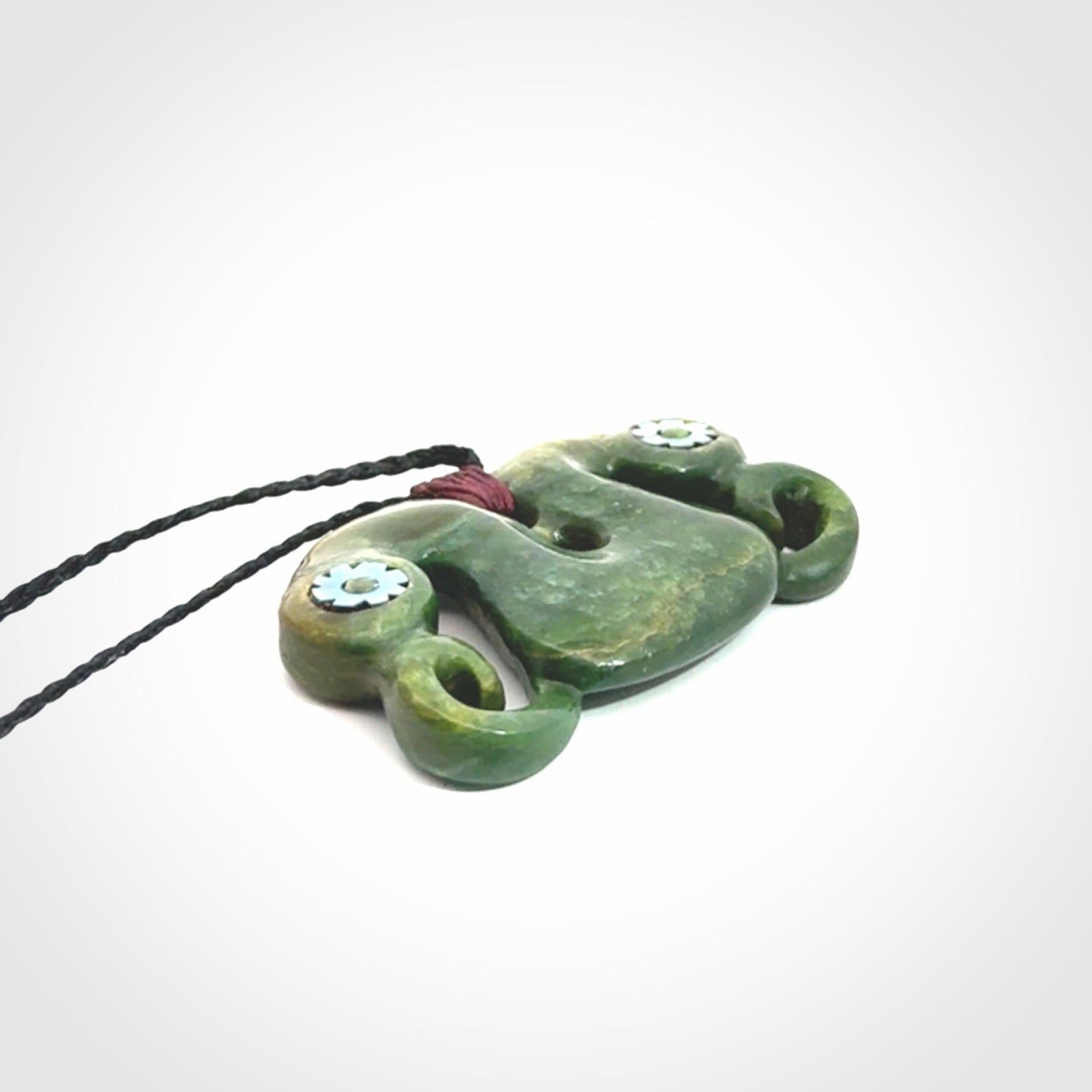Jade Pekapeka, double manaia, pendant hand made here in New Zealand. The cord is black is adjustable. Unique necklace for men and women. Pekapeka necklace hand made from New Zealand Jade with Pāua Shell and Mother of Pearl eyes.