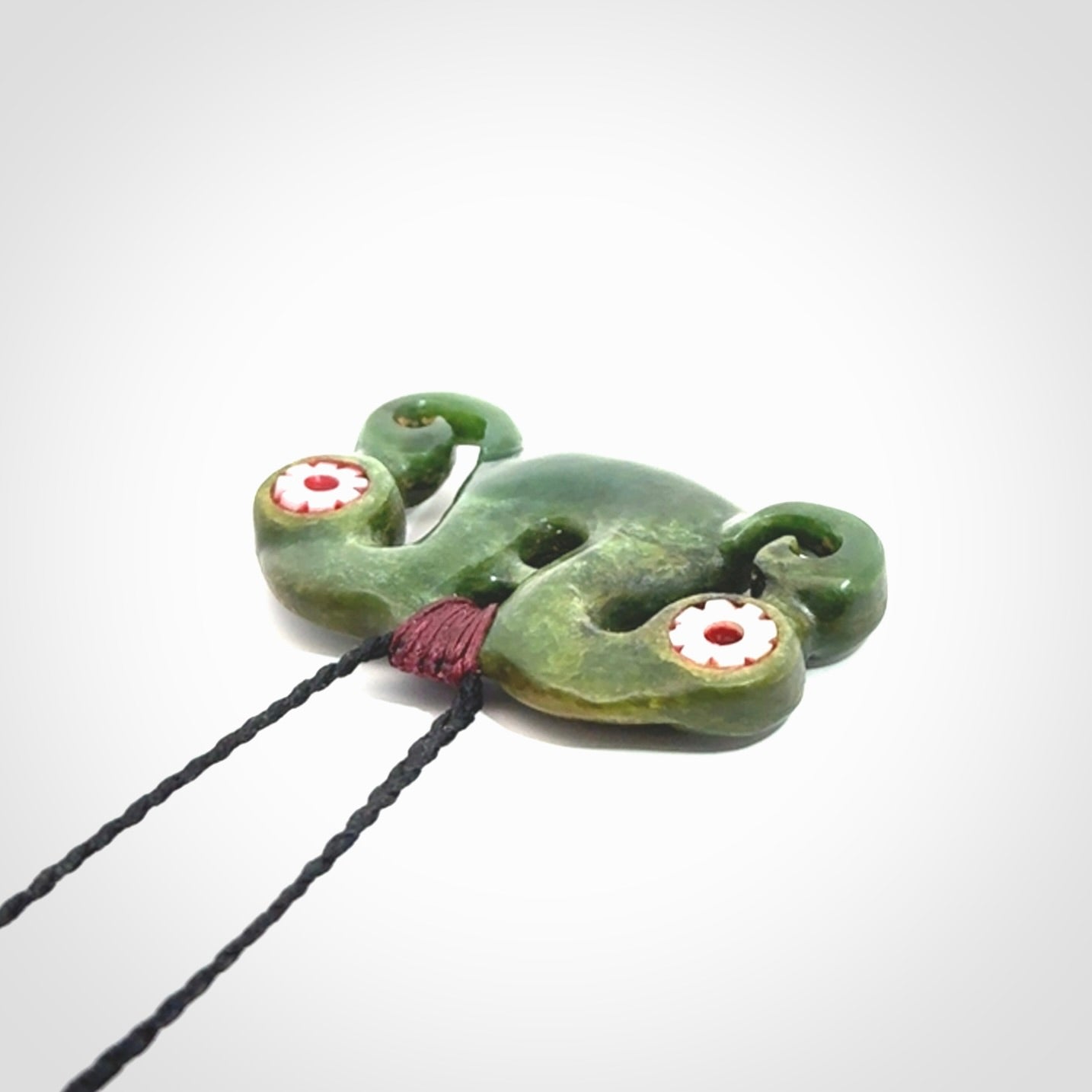Jade Pekapeka, double manaia, pendant hand made here in New Zealand. The cord is black is adjustable. Unique necklace for men and women. Pekapeka necklace hand made from New Zealand Jade with Pāua Shell and Mother of Pearl eyes.