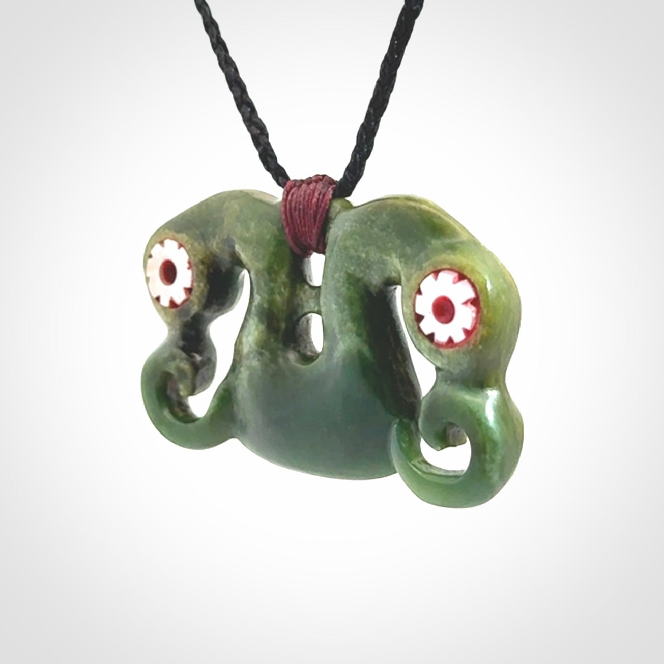 Jade Pekapeka, double manaia, pendant hand made here in New Zealand. The cord is black is adjustable. Unique necklace for men and women. Pekapeka necklace hand made from New Zealand Jade with Pāua Shell and Mother of Pearl eyes.