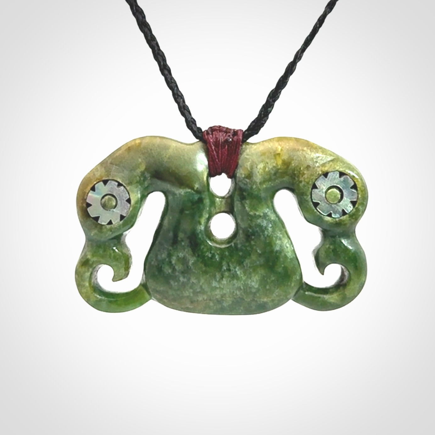 Jade Pekapeka, double manaia, pendant hand made here in New Zealand. The cord is black is adjustable. Unique necklace for men and women. Pekapeka necklace hand made from New Zealand Jade with Pāua Shell and Mother of Pearl eyes.
