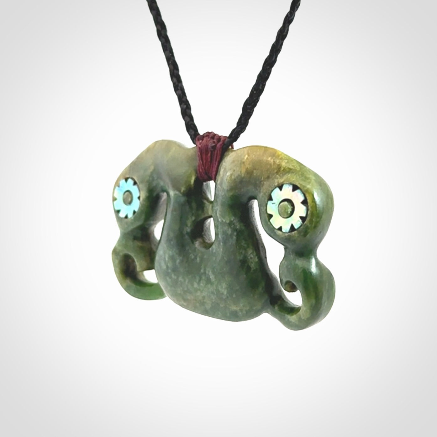 Jade Pekapeka, double manaia, pendant hand made here in New Zealand. The cord is black is adjustable. Unique necklace for men and women. Pekapeka necklace hand made from New Zealand Jade with Pāua Shell and Mother of Pearl eyes.