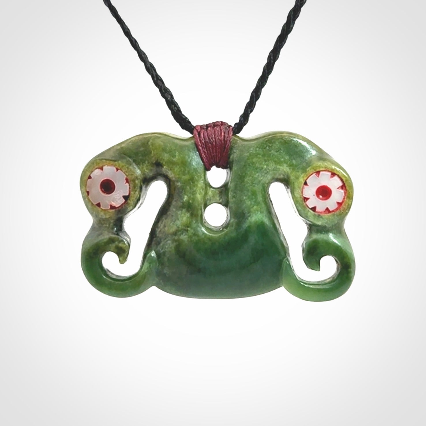 Jade Pekapeka, double manaia, pendant hand made here in New Zealand. The cord is black is adjustable. Unique necklace for men and women. Pekapeka necklace hand made from New Zealand Jade with Pāua Shell and Mother of Pearl eyes.
