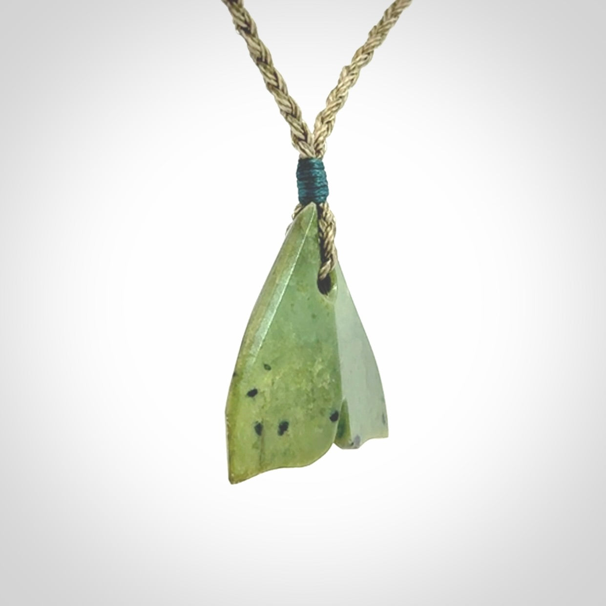 Hand carved small New Zealand Jade whale tail pendant.