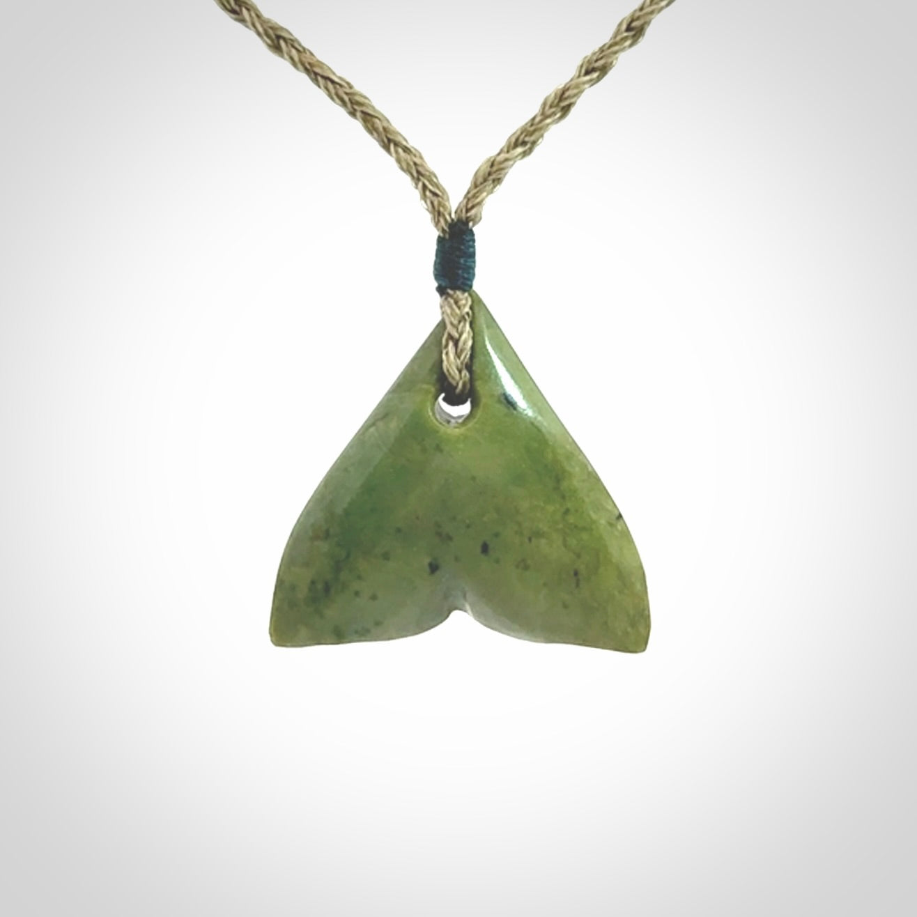 Hand carved small New Zealand Jade whale tail pendant.