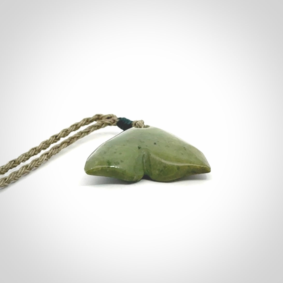 Hand carved small New Zealand Jade whale tail pendant.
