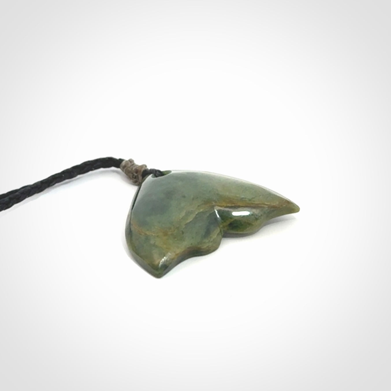 Hand carved small New Zealand Jade whale tail pendant.