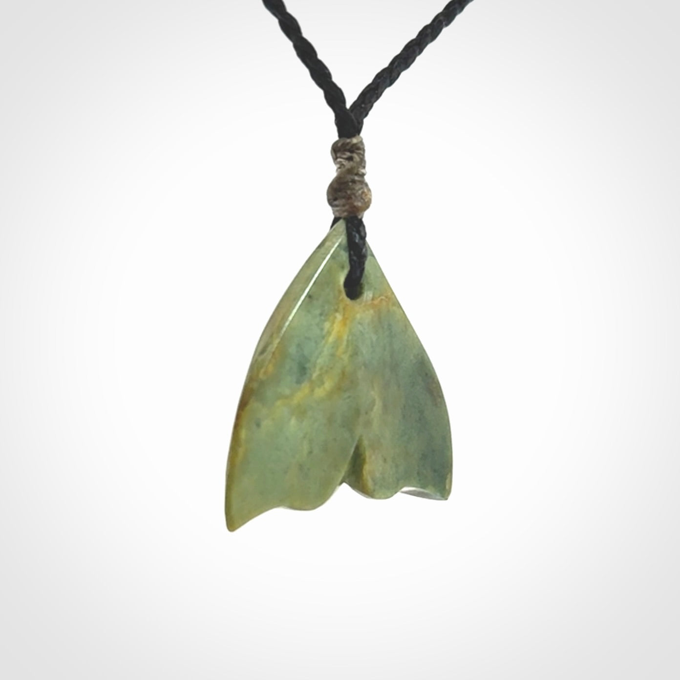 Hand carved small New Zealand Jade whale tail pendant.