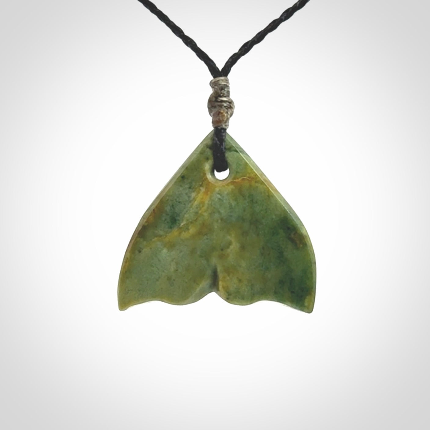 Hand carved small New Zealand Jade whale tail pendant.