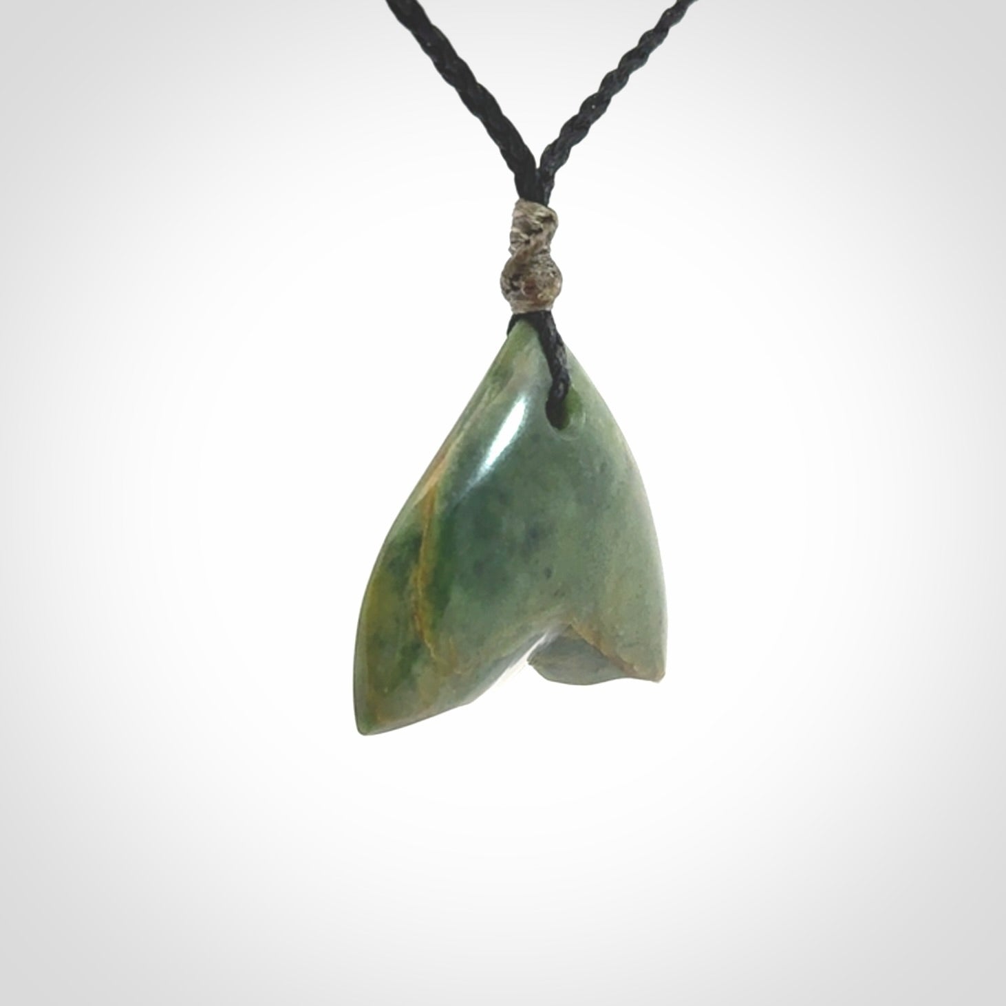 Hand carved small New Zealand Jade whale tail pendant.