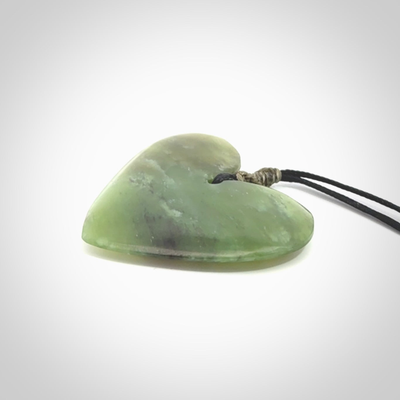 A hand carved heart pendant made from New Zealand jade.