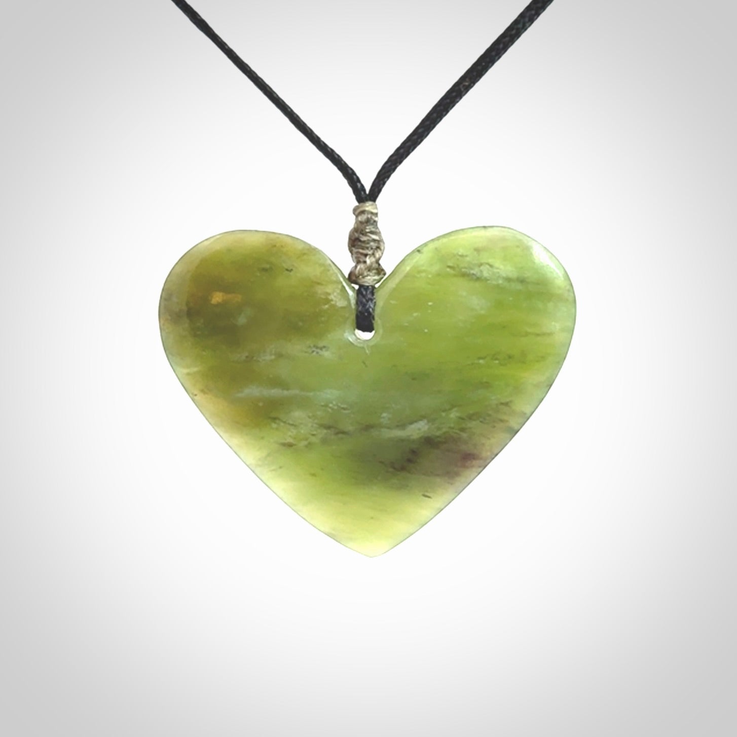 A hand carved heart pendant made from New Zealand jade.