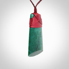 This is a handcrafted aotea stone Toki pendant.