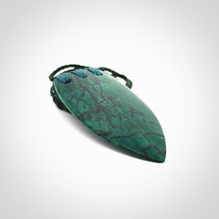 This is a handcrafted aotea stone rei puta pendant.