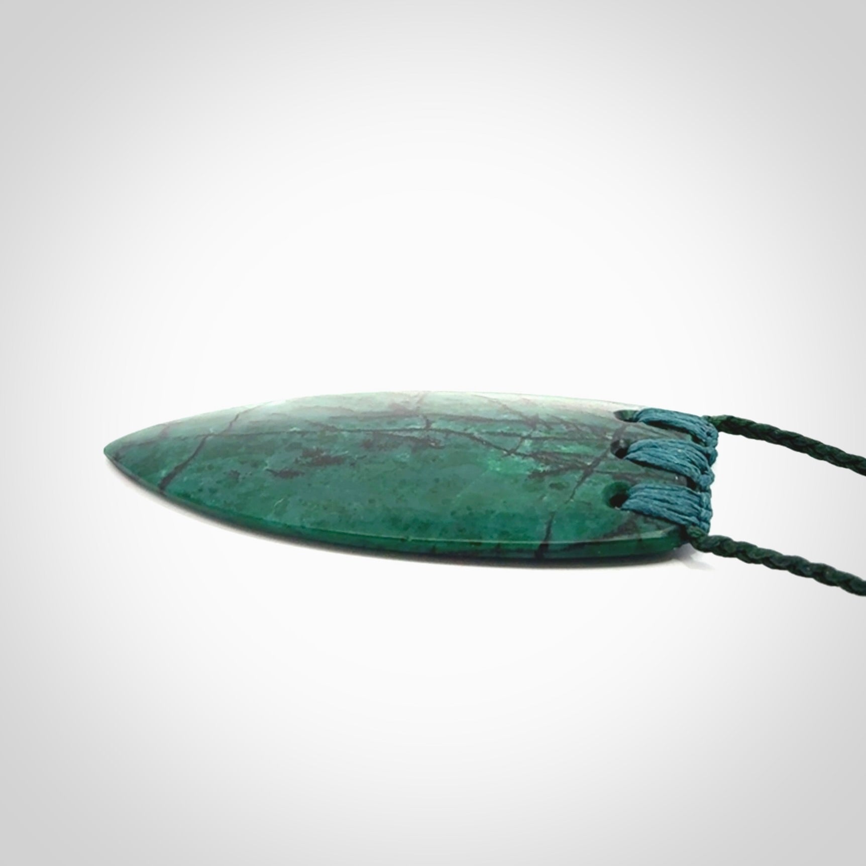 This is a handcrafted aotea stone rei puta pendant.