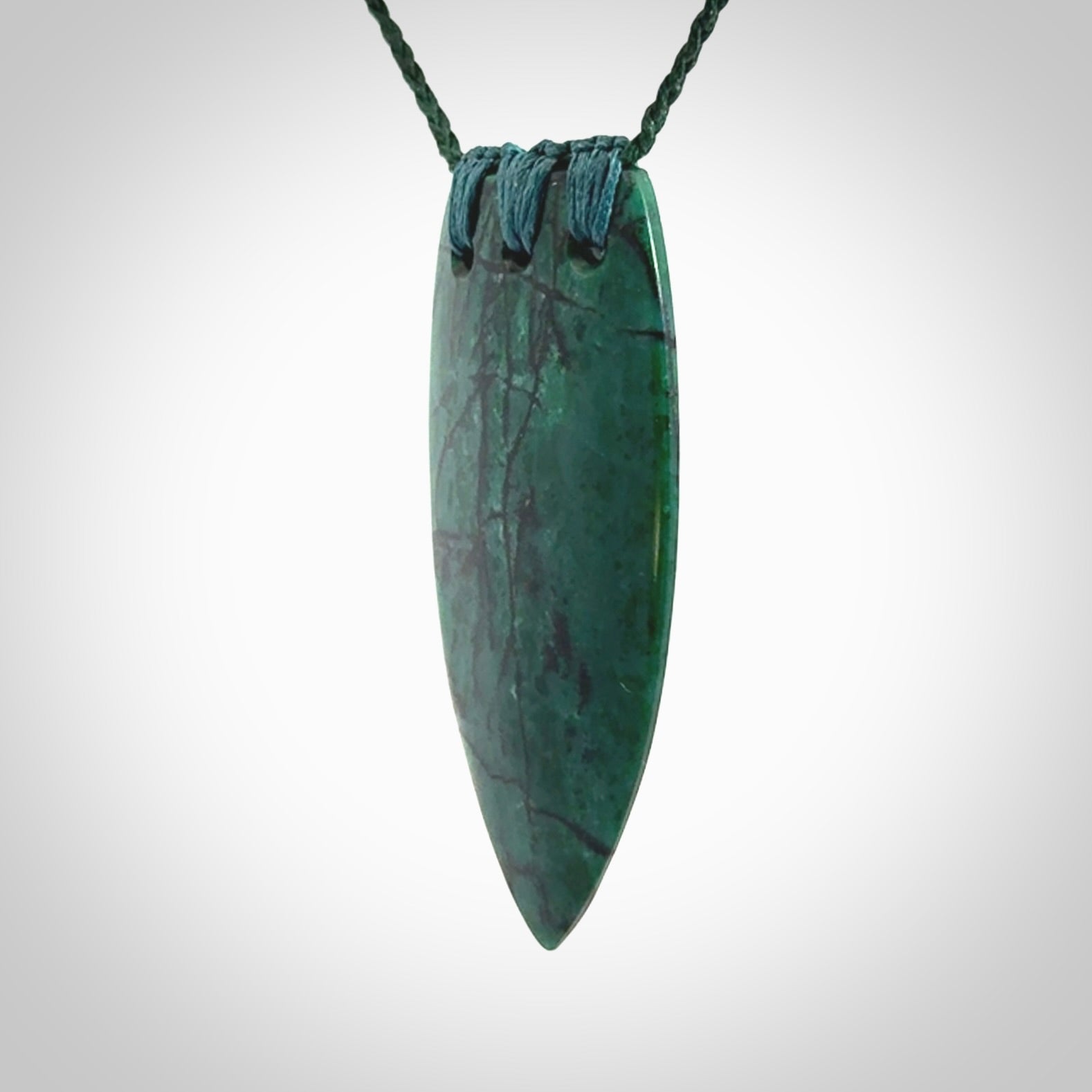 This is a handcrafted aotea stone rei puta pendant.