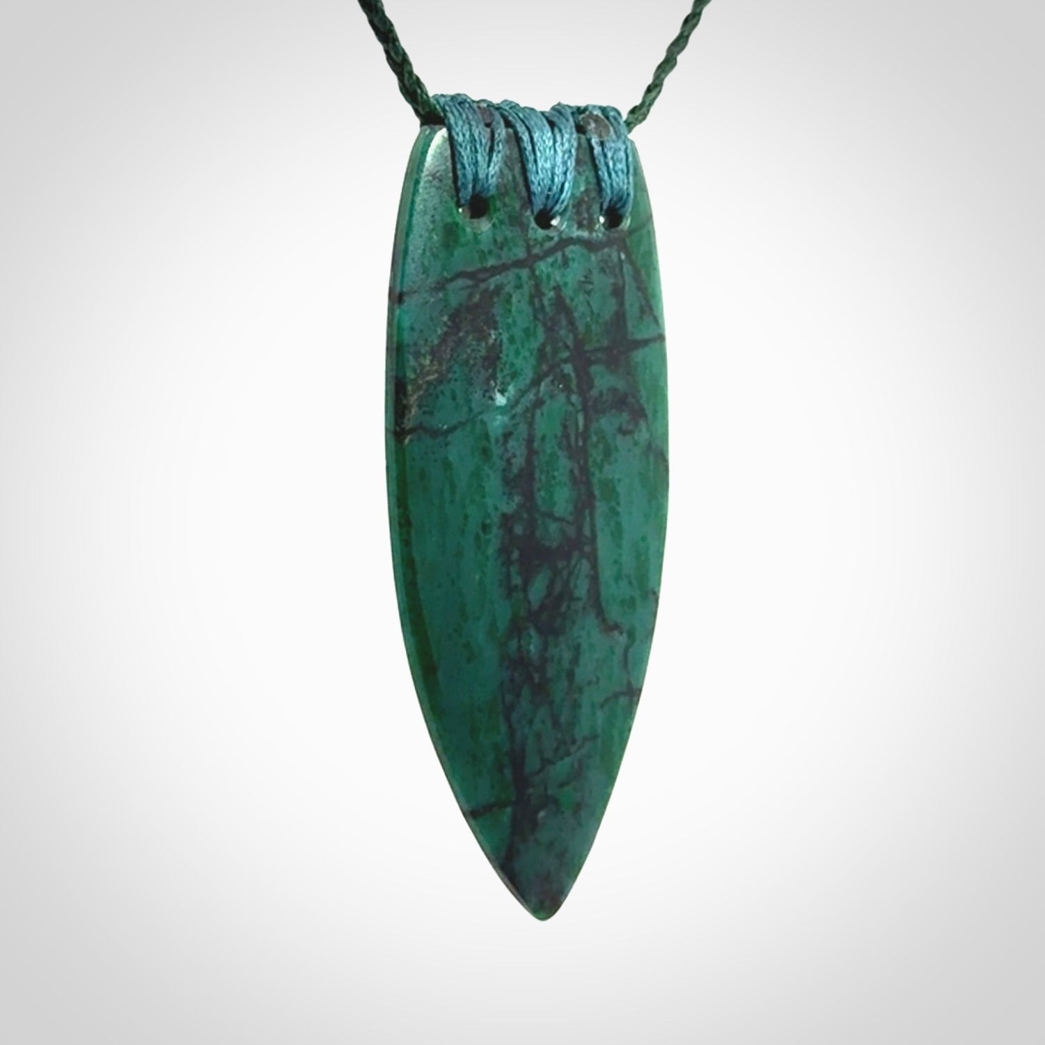 This is a handcrafted aotea stone rei puta pendant.