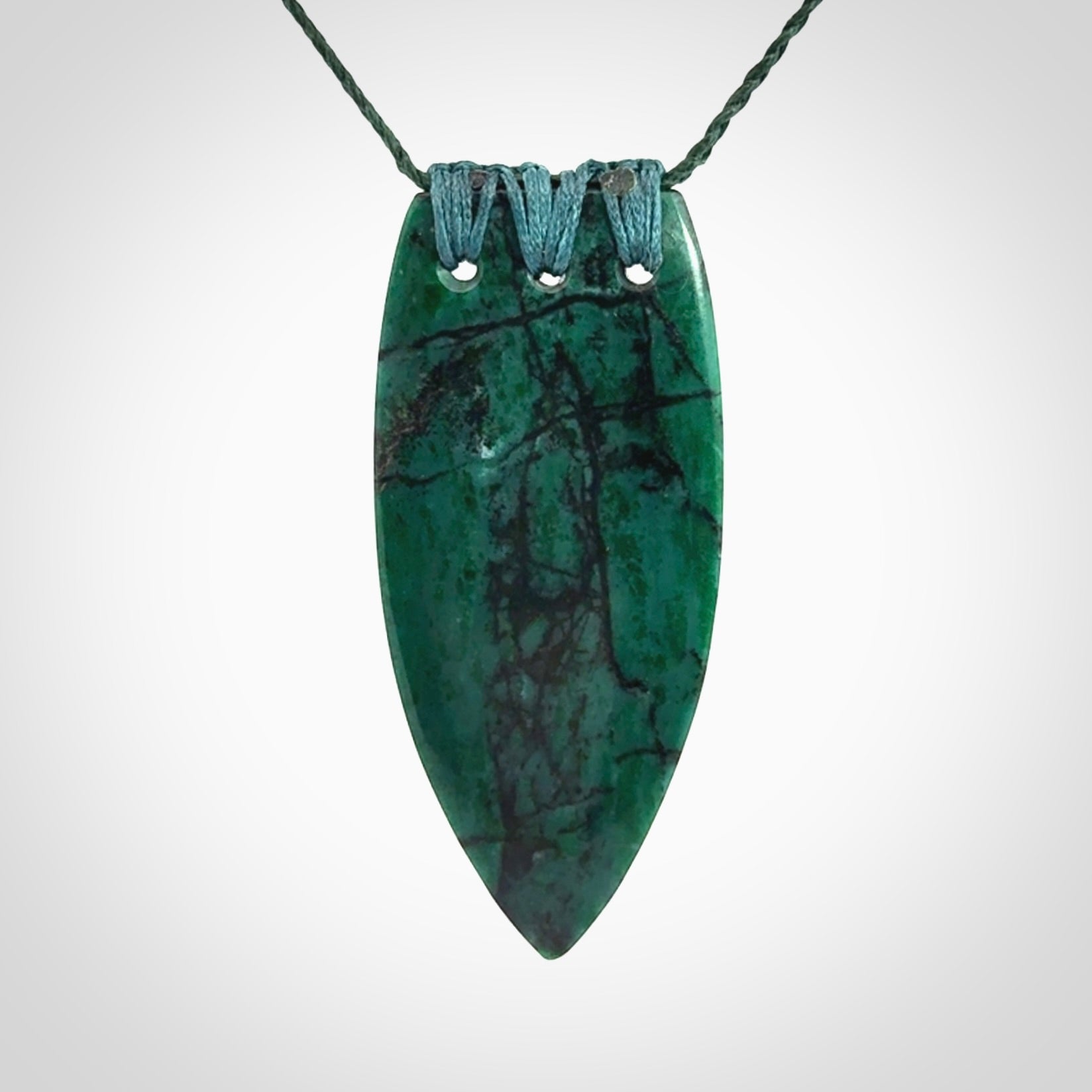 This is a handcrafted aotea stone rei puta pendant.