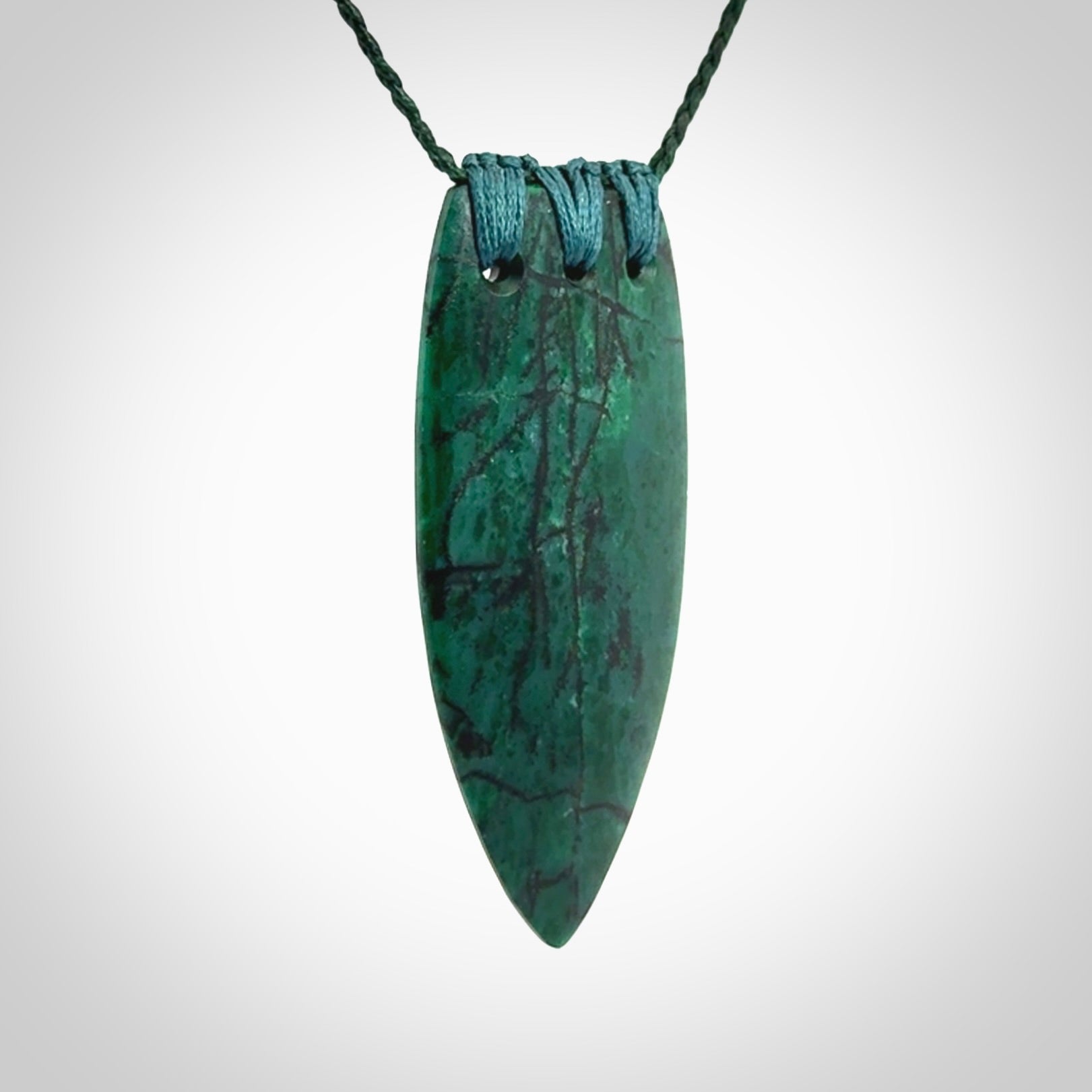 This is a handcrafted aotea stone rei puta pendant.