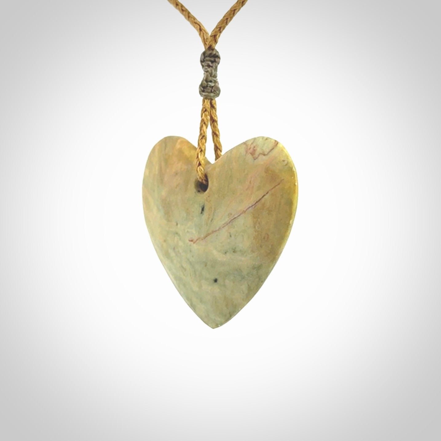 A hand carved heart pendant made from New Zealand Flower jade.