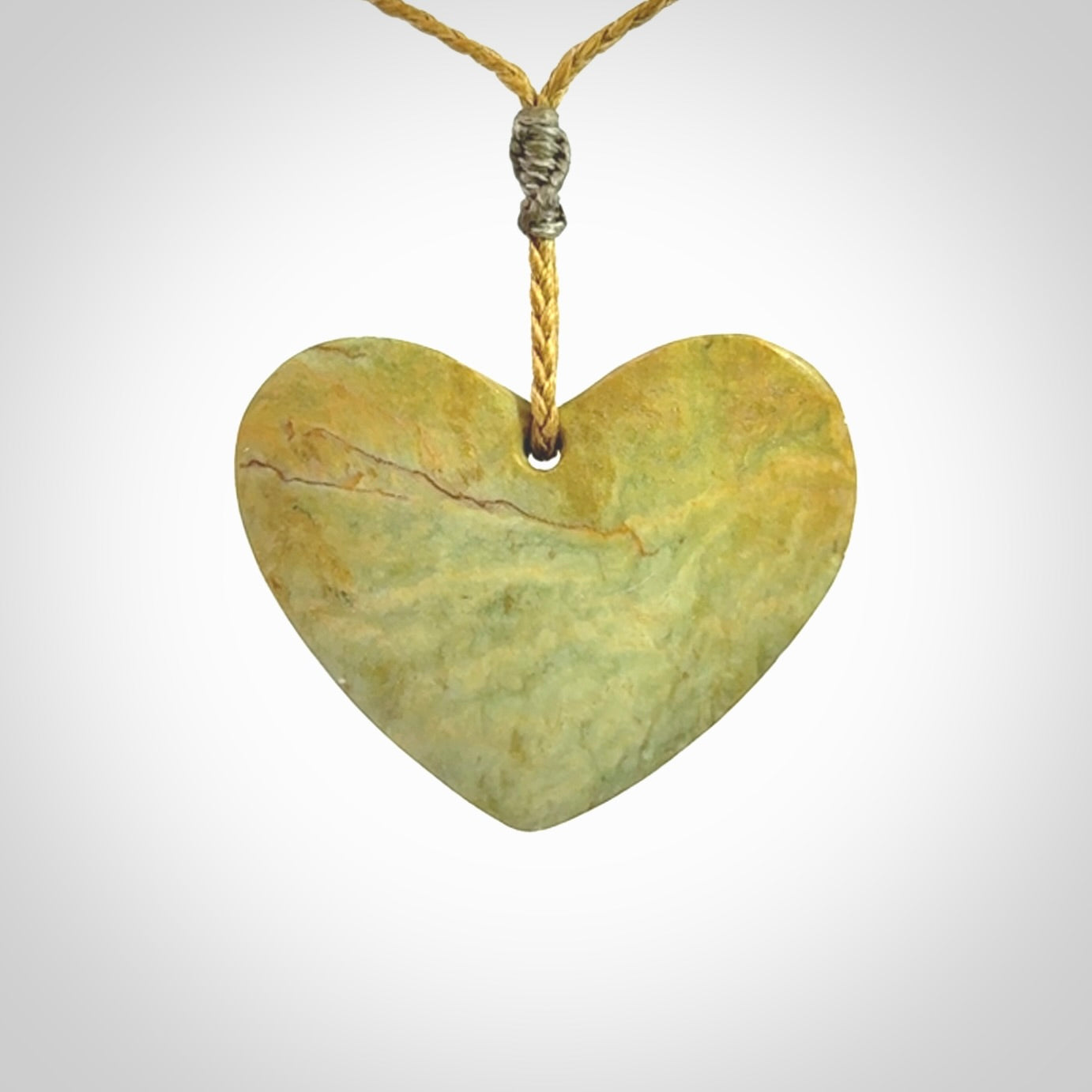 A hand carved heart pendant made from New Zealand Flower jade.