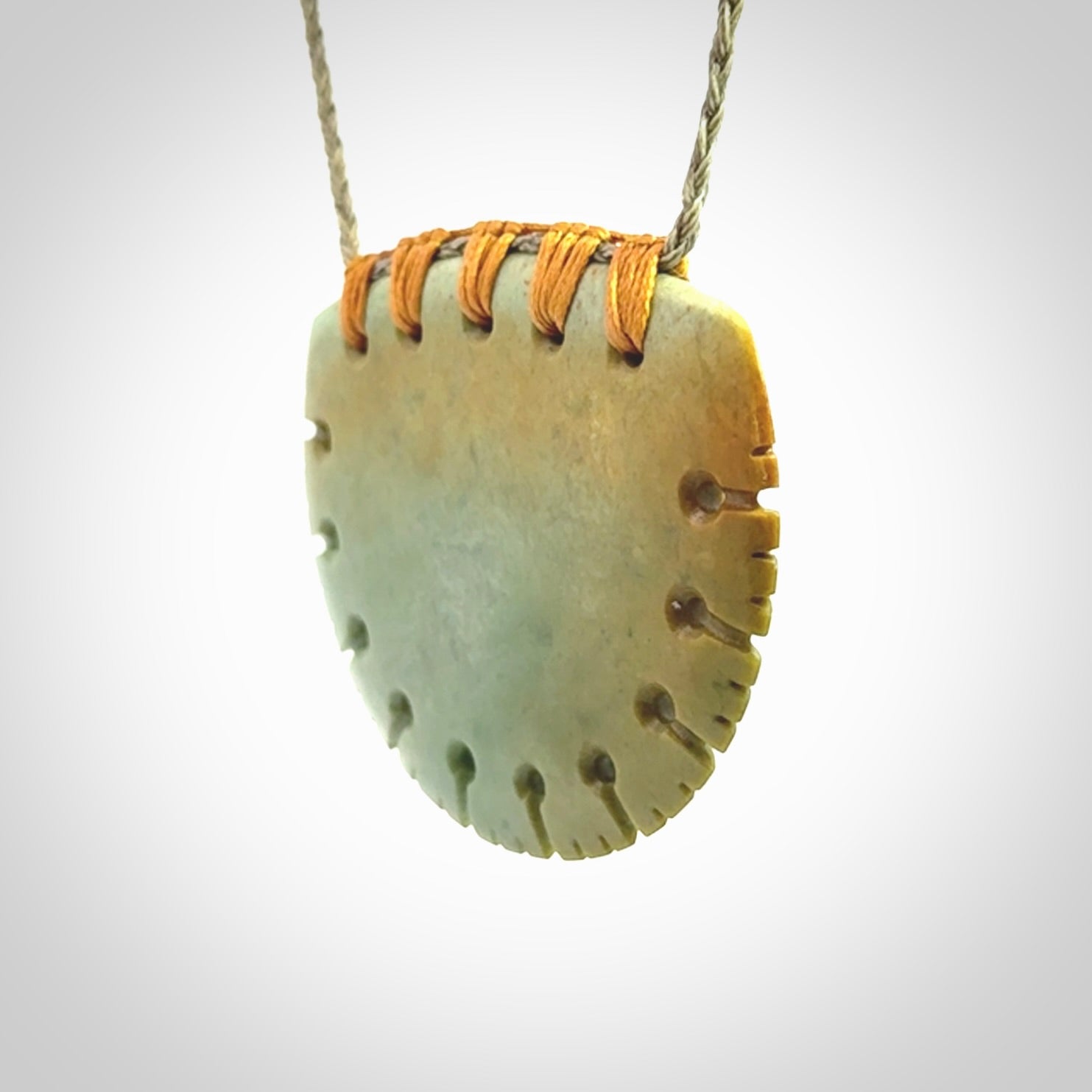 Hand carved New Zealand Flower Jade half-shield pendant.