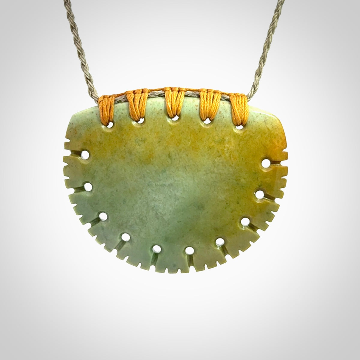 Hand carved New Zealand Flower Jade half-shield pendant.
