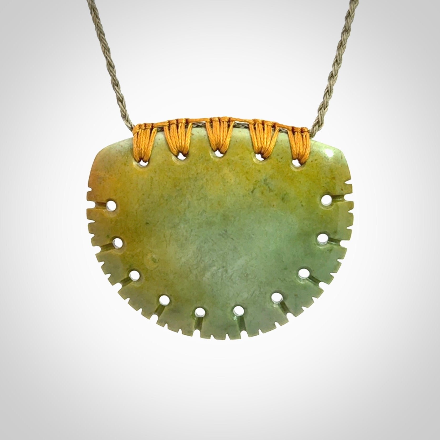 Hand carved New Zealand Flower Jade half-shield pendant.