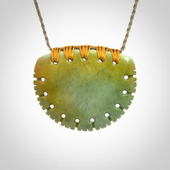Hand carved New Zealand Flower Jade half-shield pendant.