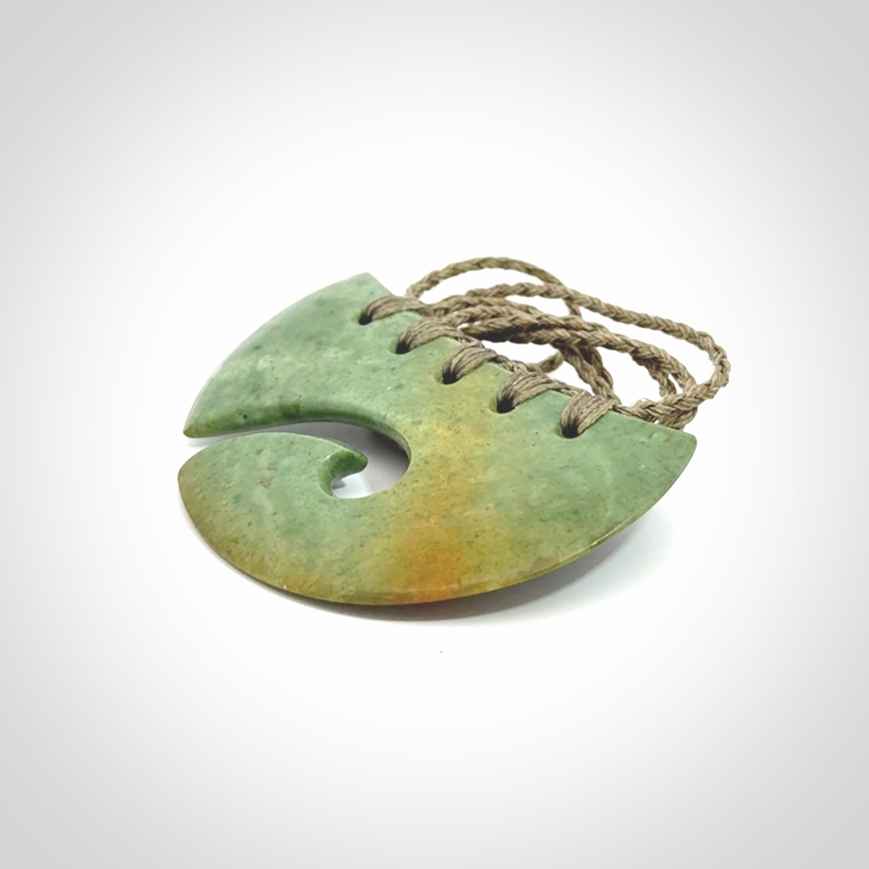 Hand carved New Zealand Flower Jade half-shield with koru pendant.