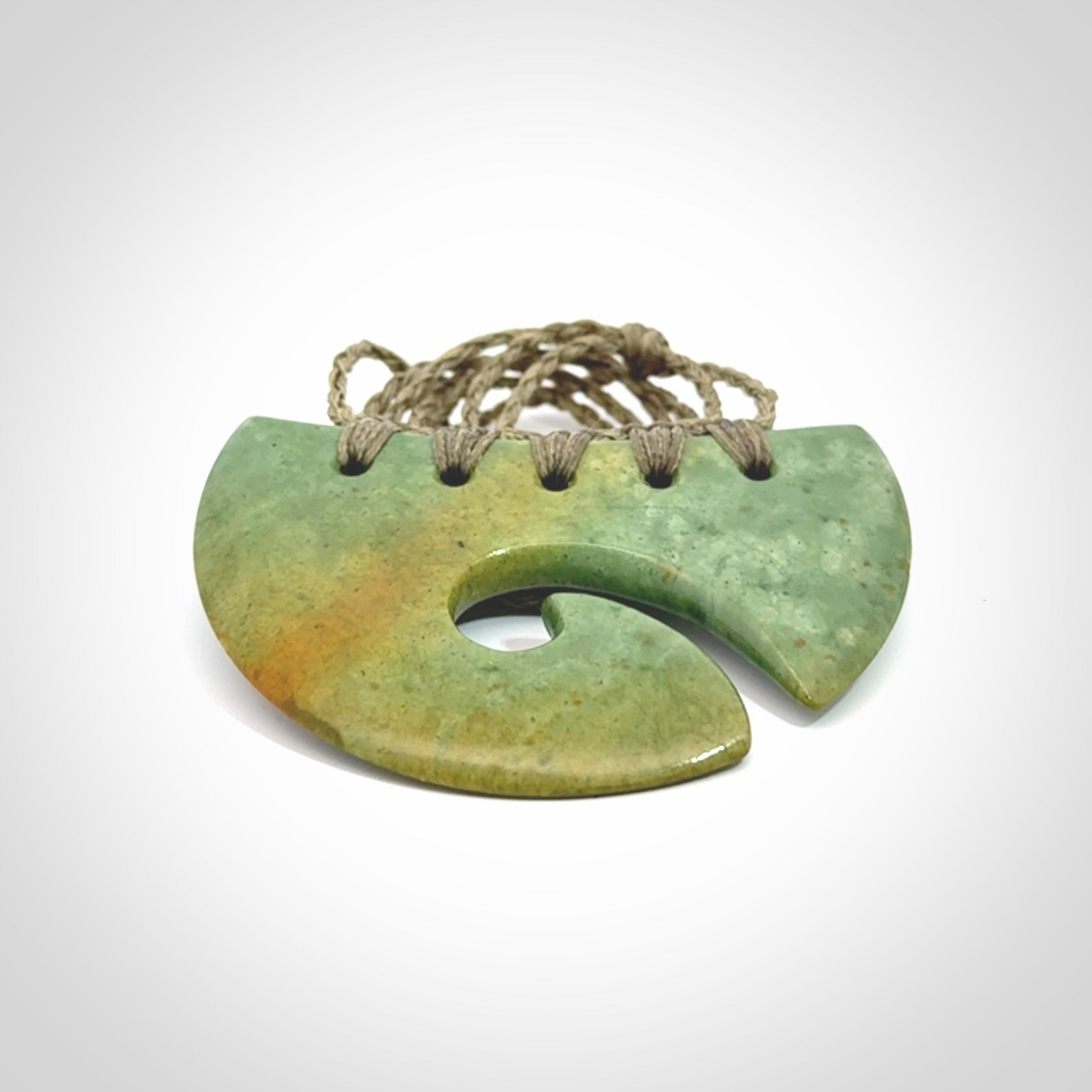 Hand carved New Zealand Flower Jade half-shield with koru pendant.