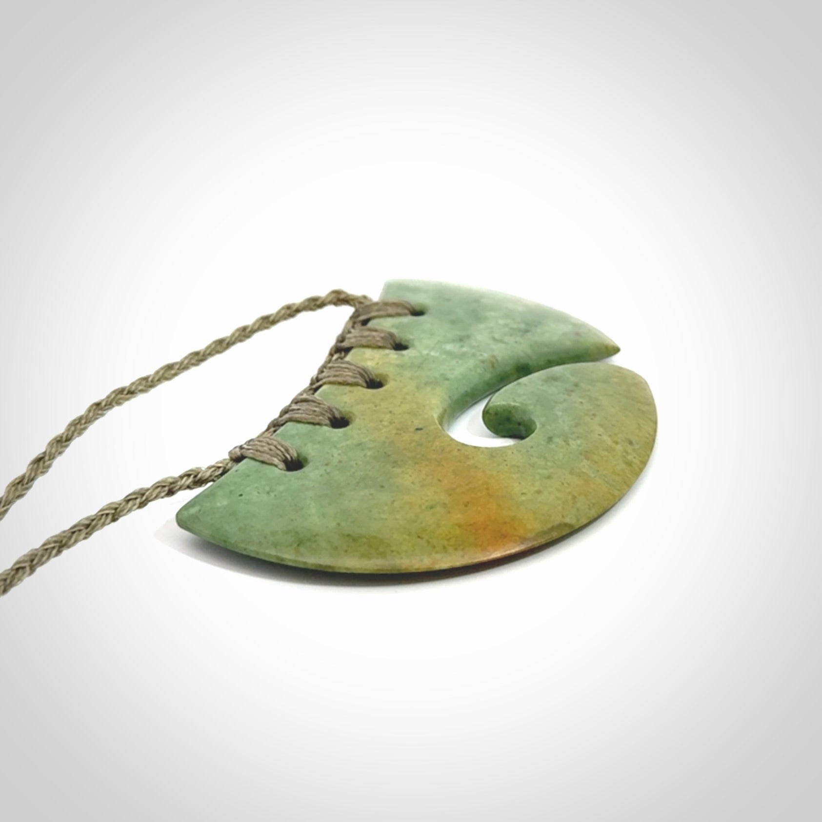 Hand carved New Zealand Flower Jade half-shield with koru pendant.