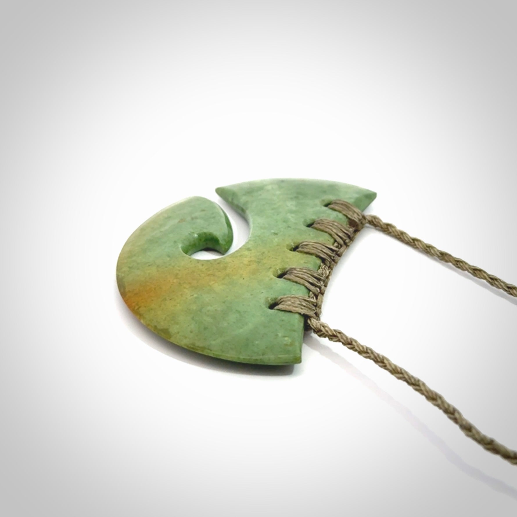Hand carved New Zealand Flower Jade half-shield with koru pendant.