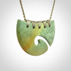 Hand carved New Zealand Flower Jade half-shield with koru pendant.