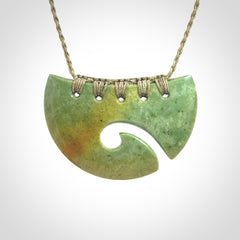 Hand carved New Zealand Flower Jade half-shield with koru pendant.