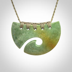 Hand carved New Zealand Flower Jade half-shield with koru pendant.
