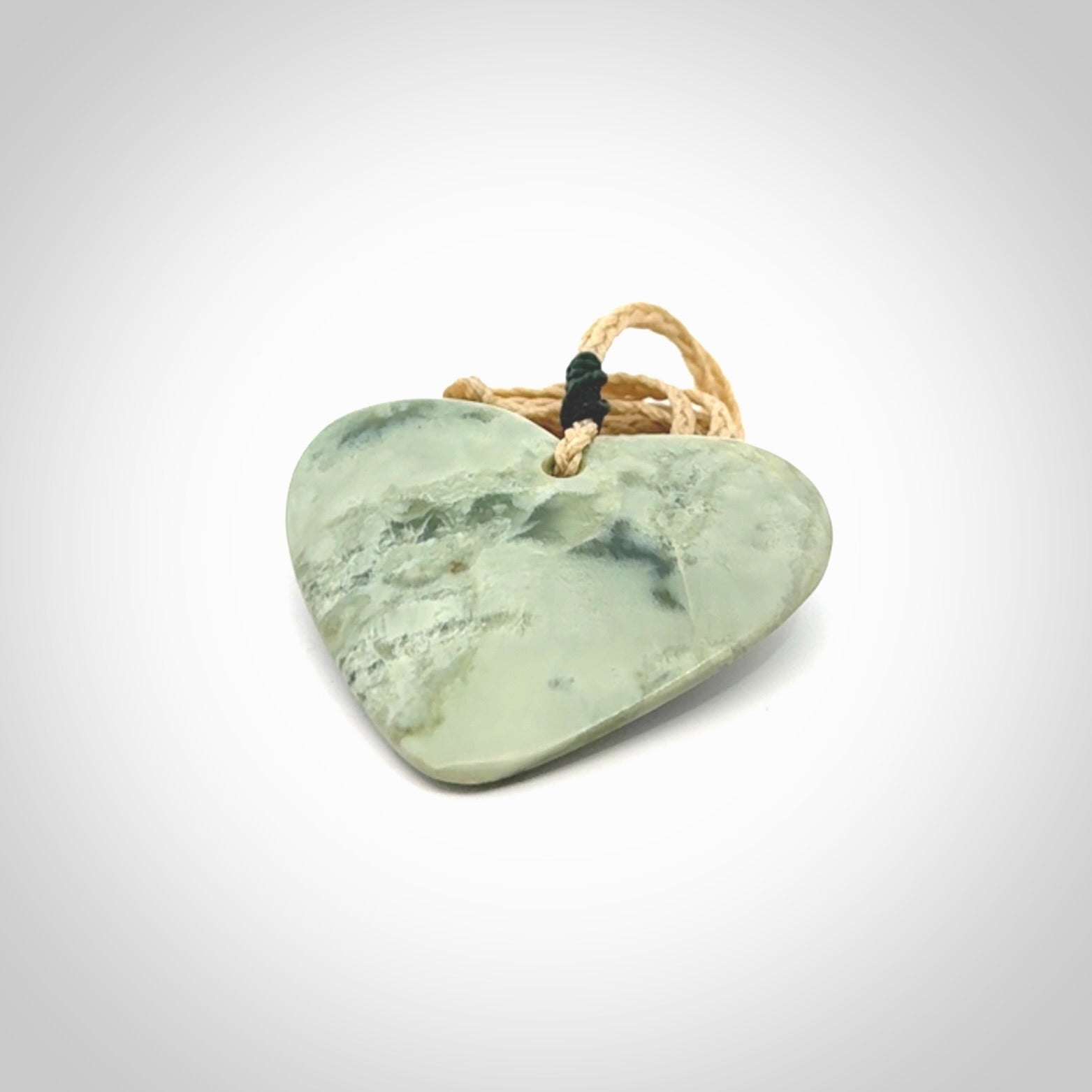 A hand carved heart pendant made from New Zealand jade.