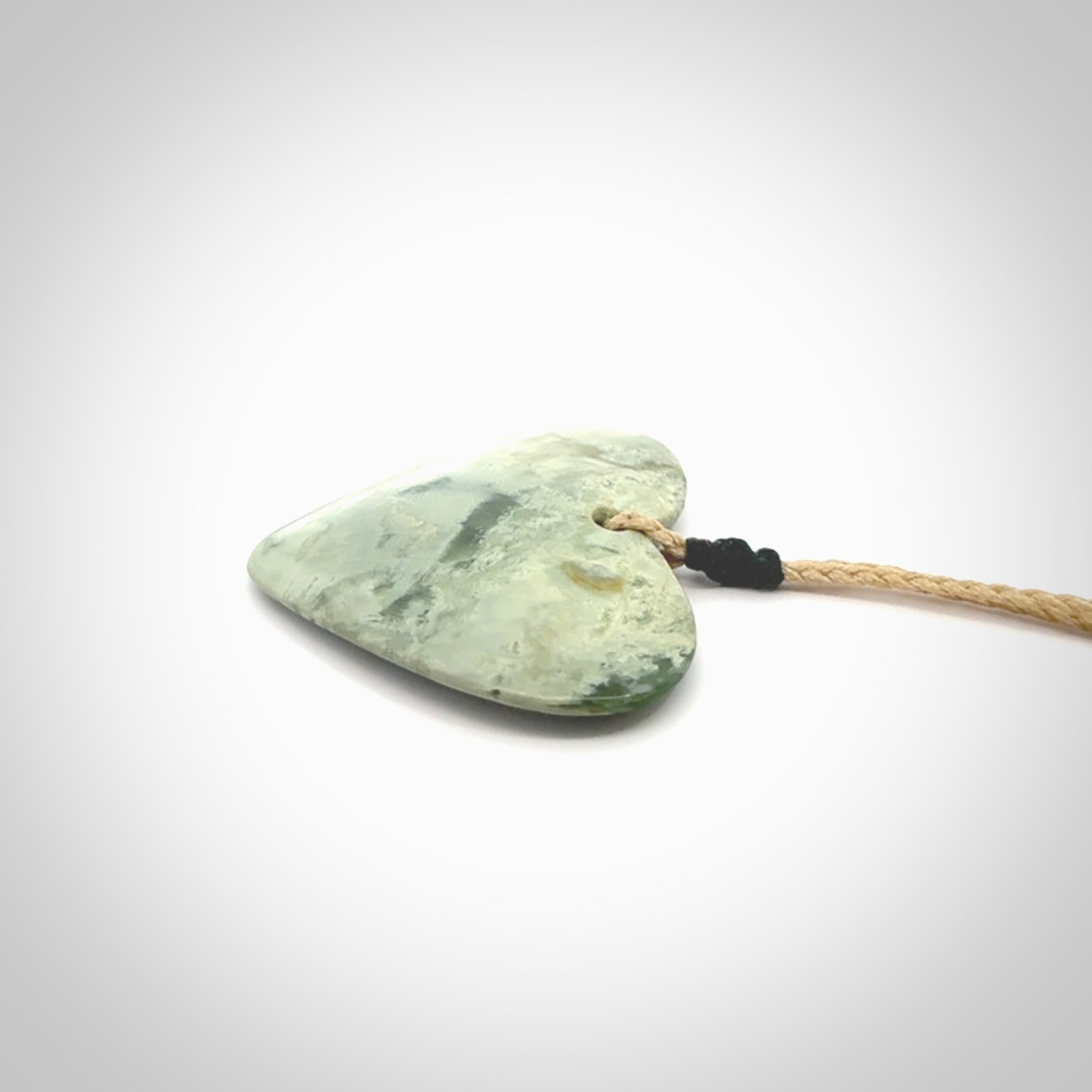 A hand carved heart pendant made from New Zealand jade.