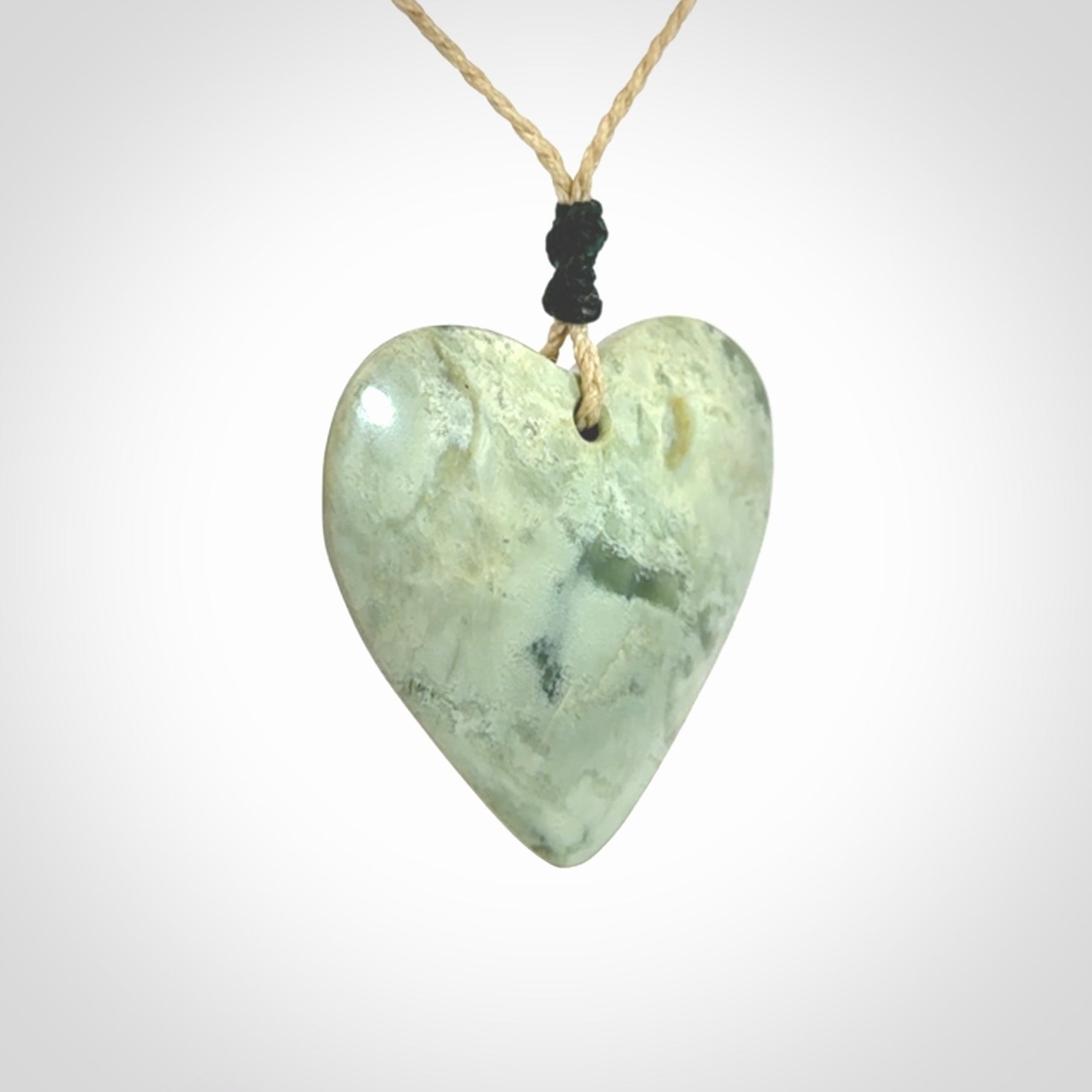 A hand carved heart pendant made from New Zealand jade.