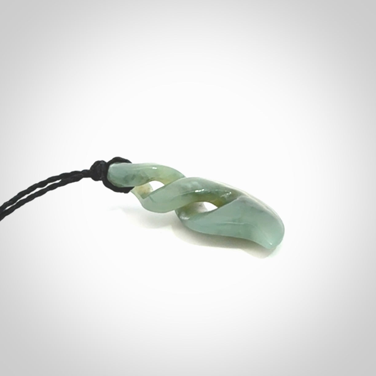 Hand carved small sized, New Zealand Inanga jade double twist pendant.