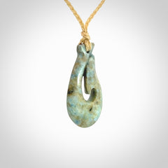 This is a handcrafted aotea stone Hook pendant.