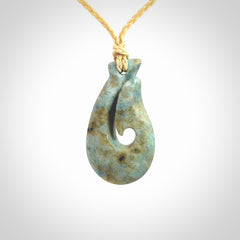 This is a handcrafted aotea stone Hook pendant.
