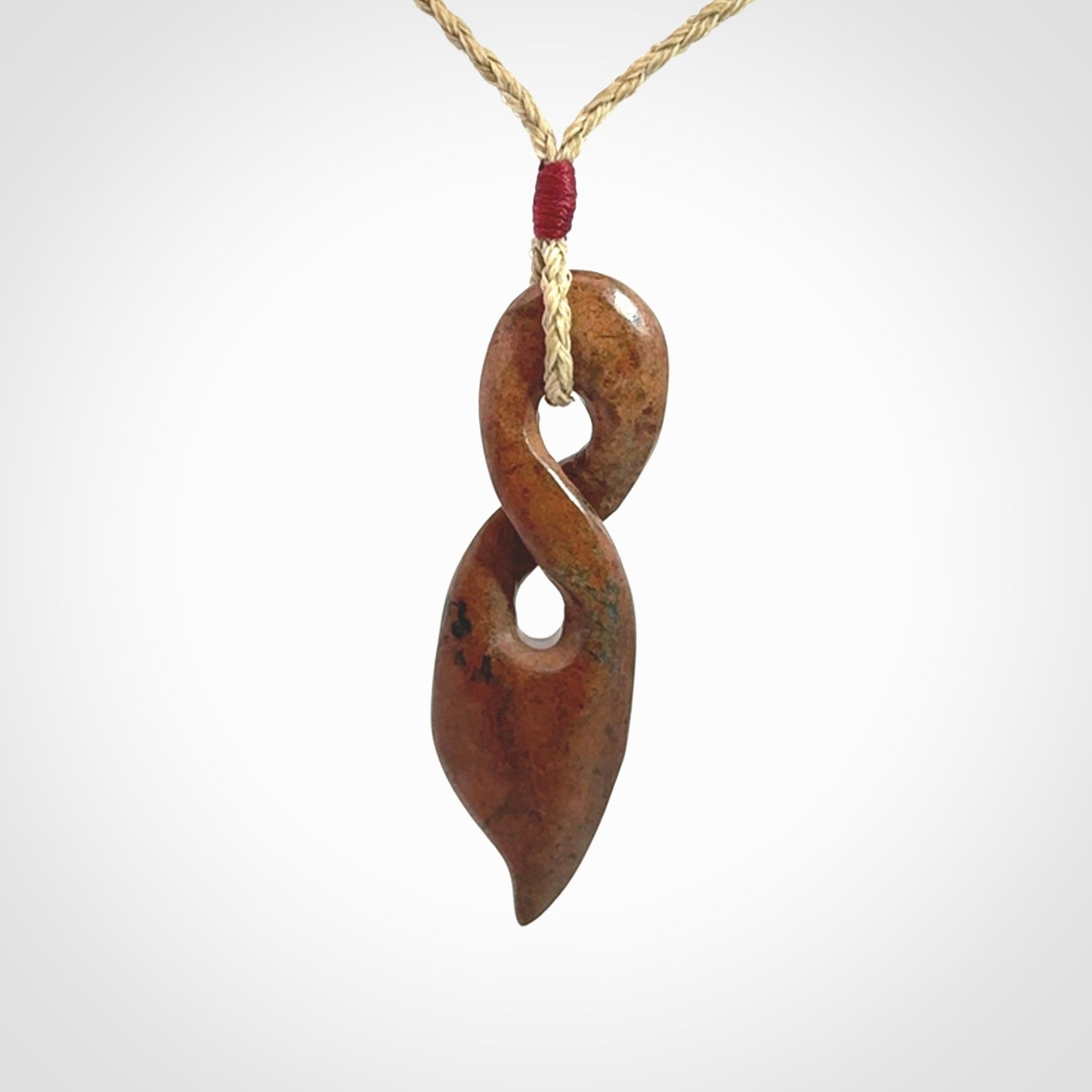 A wonderful twist pendant carved in jade that has been heated