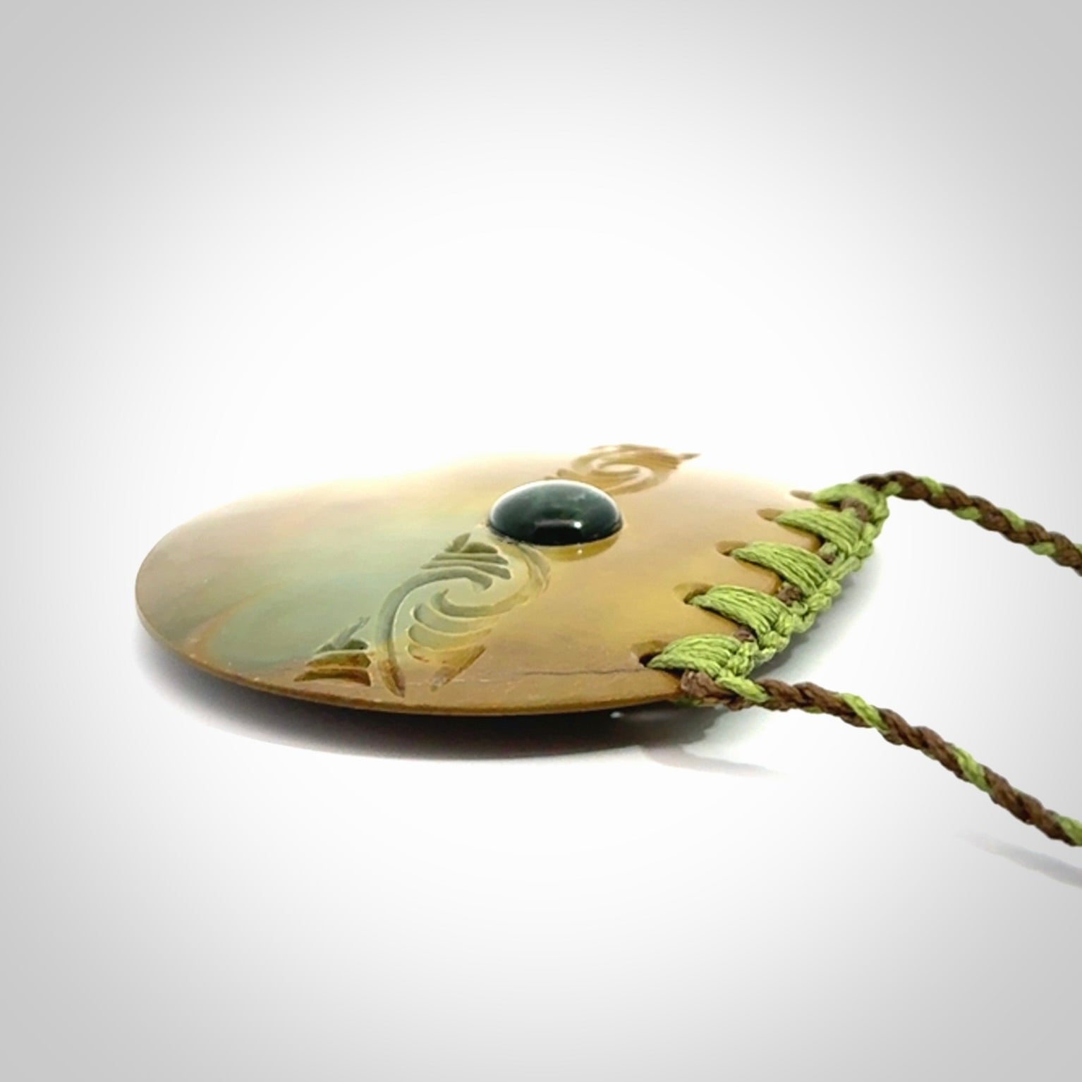Hand carved New Zealand Flower Jade half-shield with whakarei design pendant.