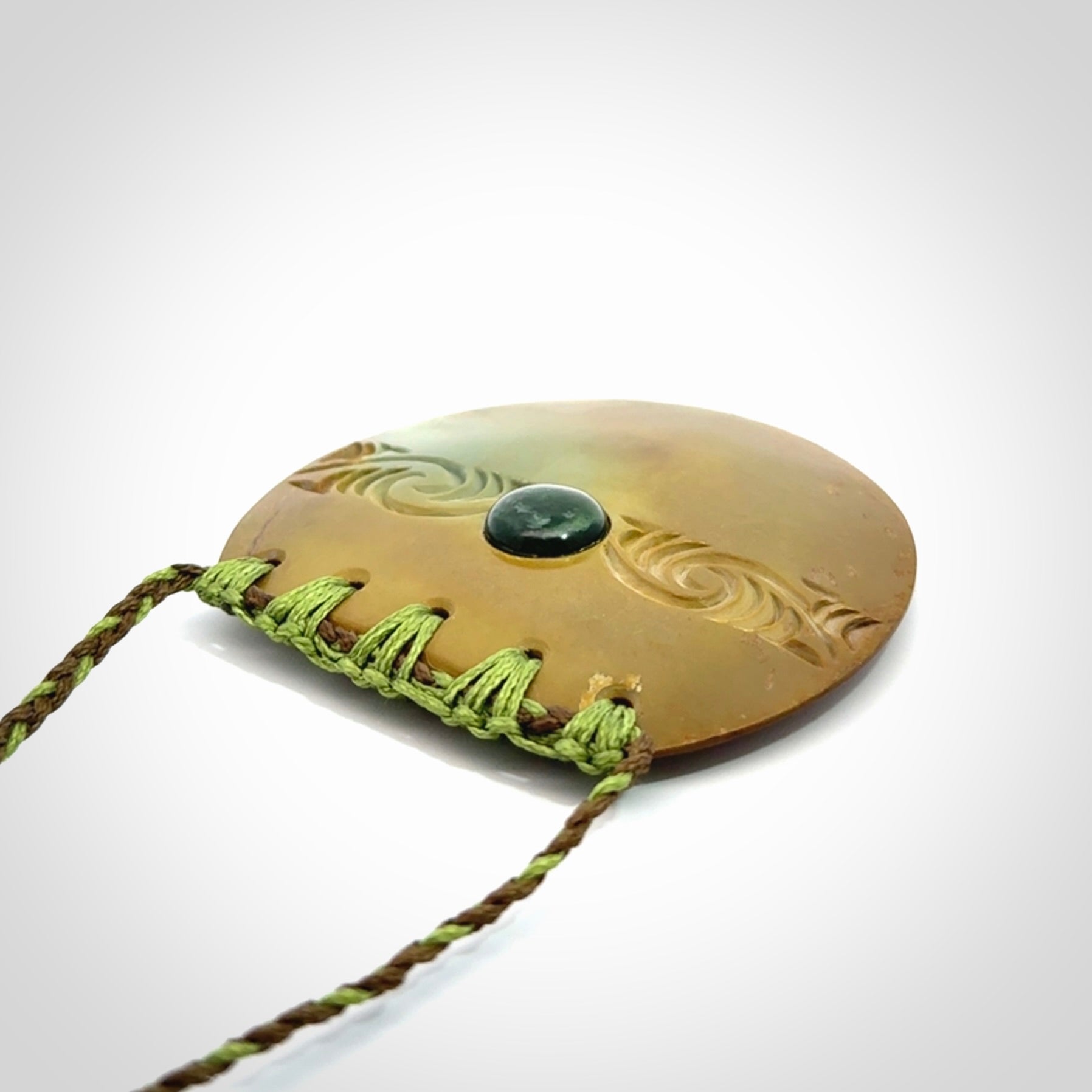 Hand carved New Zealand Flower Jade half-shield with whakarei design pendant.