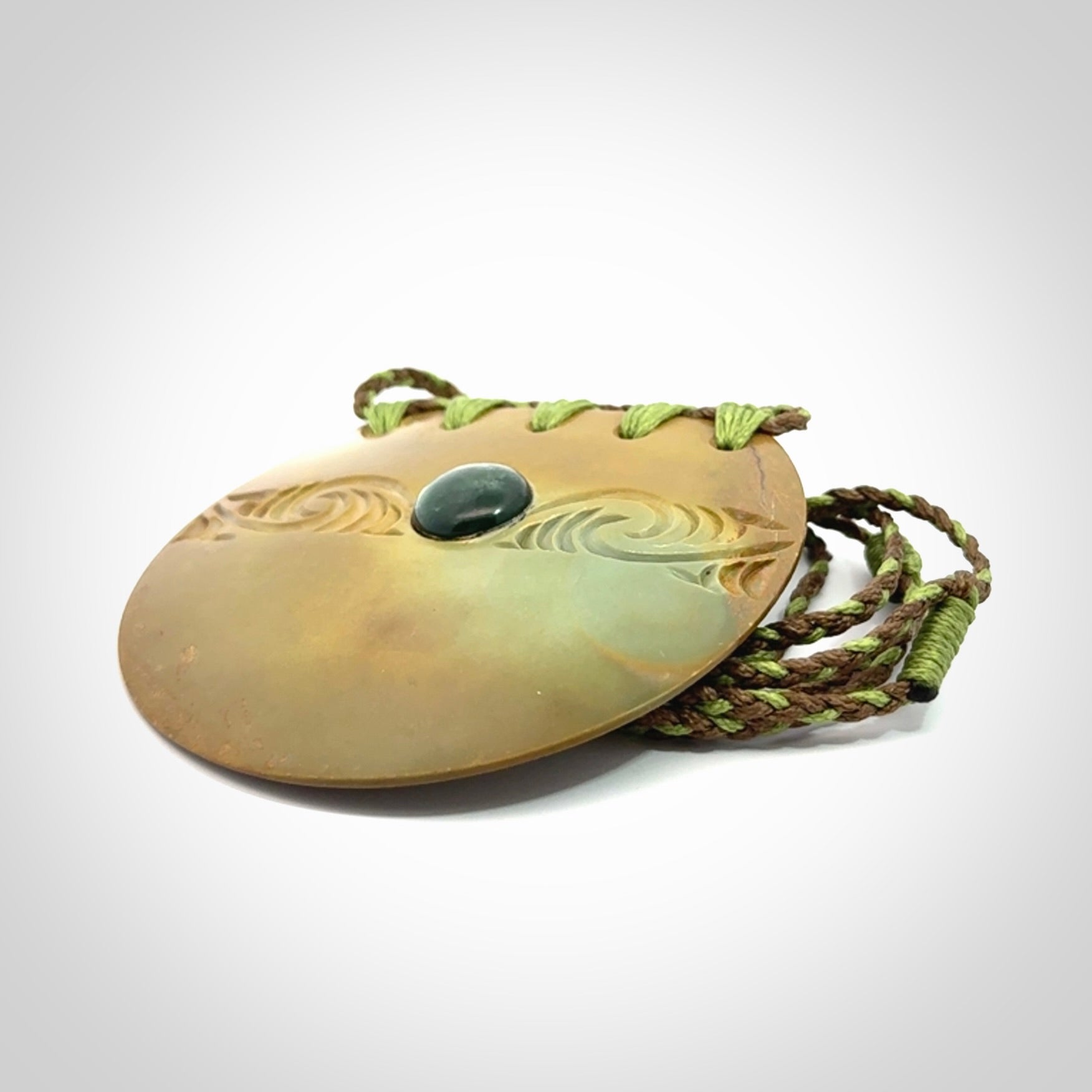 Hand carved New Zealand Flower Jade half-shield with whakarei design pendant.